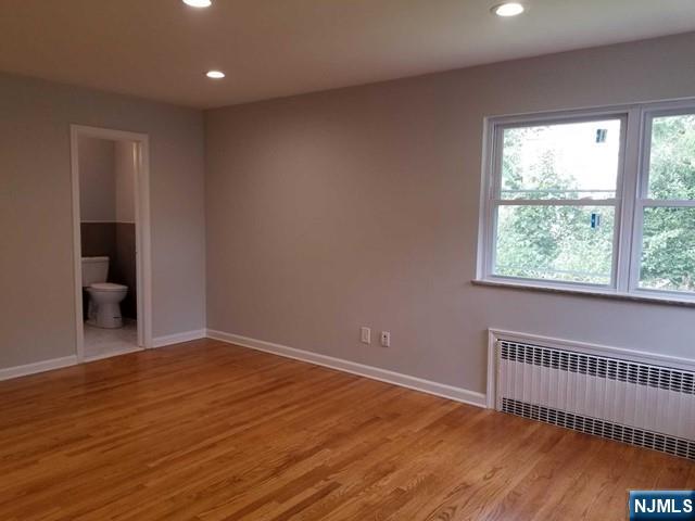 229 Mohegan Way Fort Lee, NJ 07024 - Photo 6 of 14 a view of an empty room with wooden floor and a window