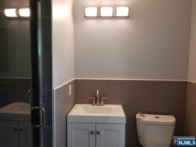 229 Mohegan Way Fort Lee, NJ 07024 - Photo 7 of 14 a bathroom with a toilet a sink and mirror