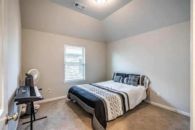 a bed sitting in a bedroom next to a window