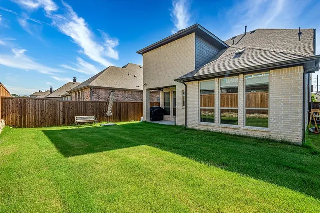 a view of a house with a big yard and large tree
