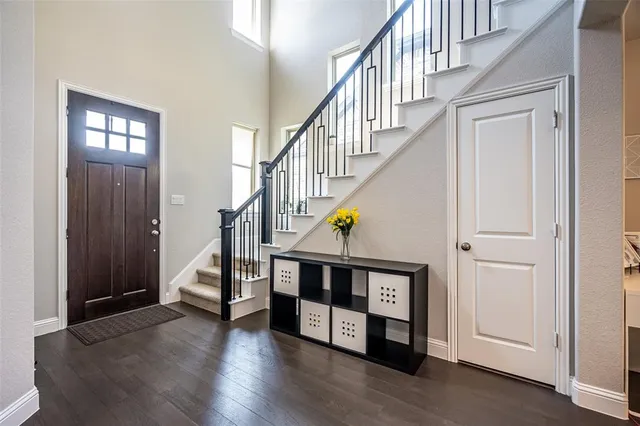 a view of staircase with lots of frames on wall and wooden floor