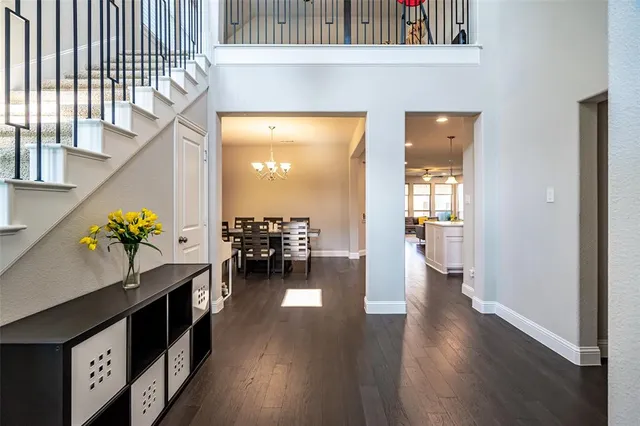 a hallway with wooden floor table and chairs