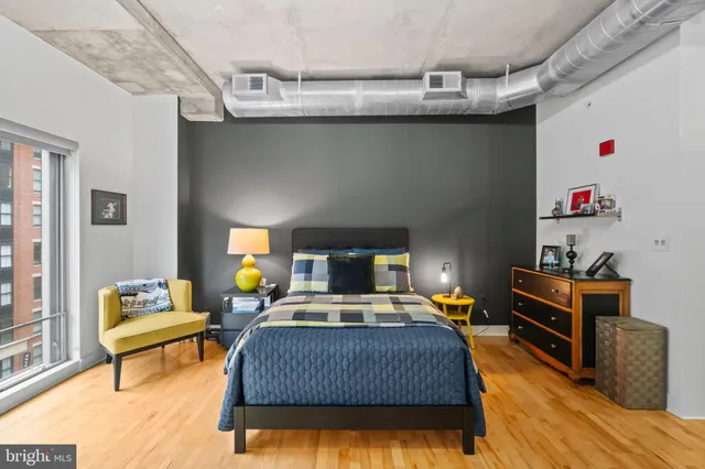 a bedroom with a bed and wooden floor