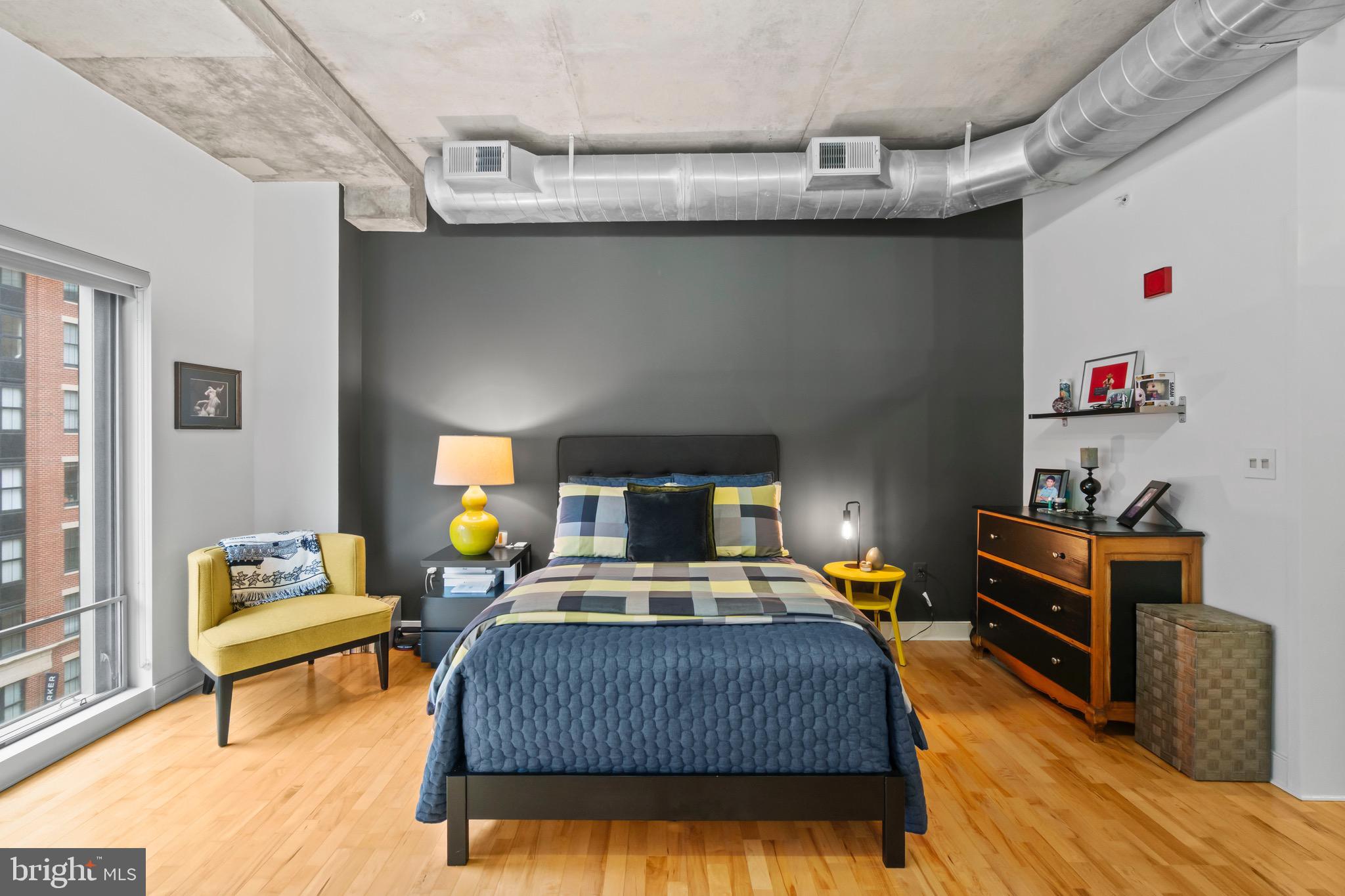 850 Aliceanna Street, Unit 604 Baltimore, MD 21202 - Photo 17 of 43 a bedroom with a bed and wooden floor