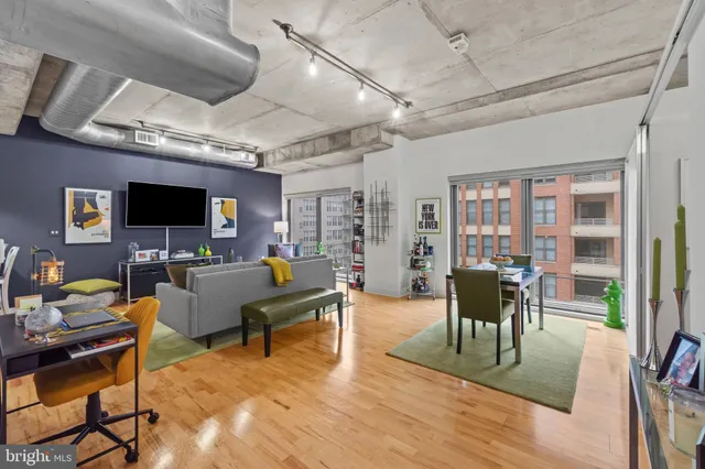 a living room with furniture a flat screen tv and a floor to ceiling window