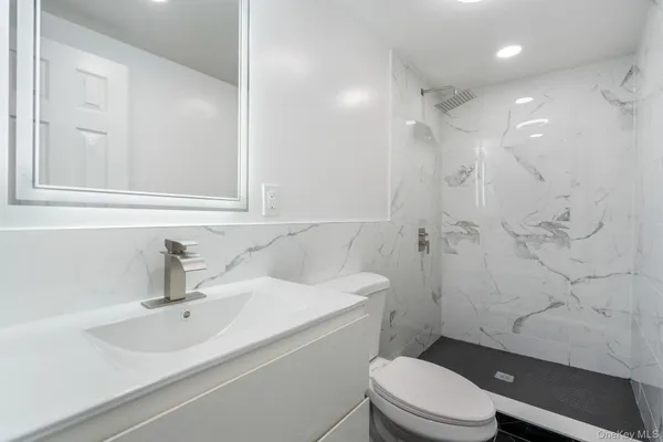 a bathroom with a sink a toilet and shower