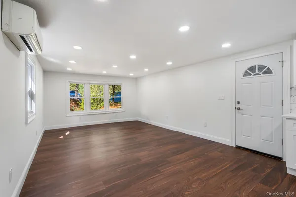 an empty room with window and wooden floor
