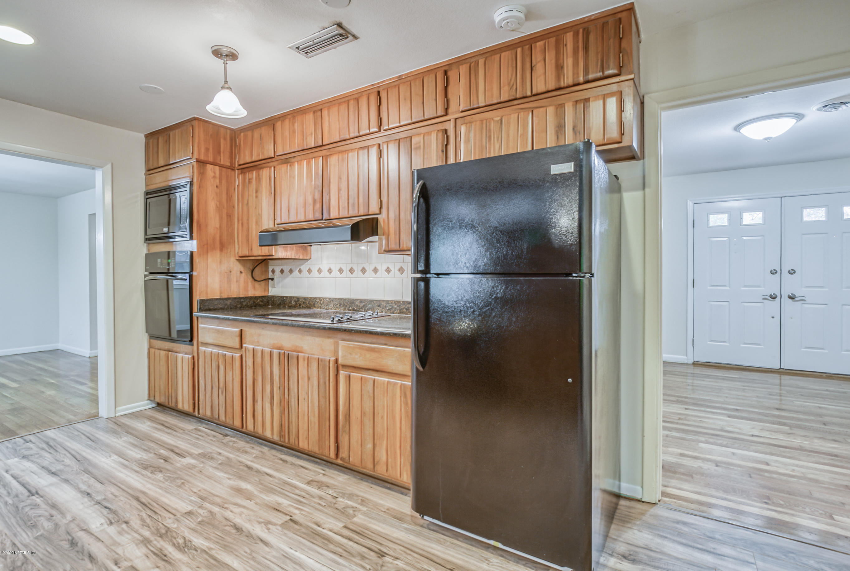 1305 Timber Lane Jacksonville, FL 32211 - Photo 13 of 58 a kitchen with granite countertop a refrigerator a sink and white cabinets