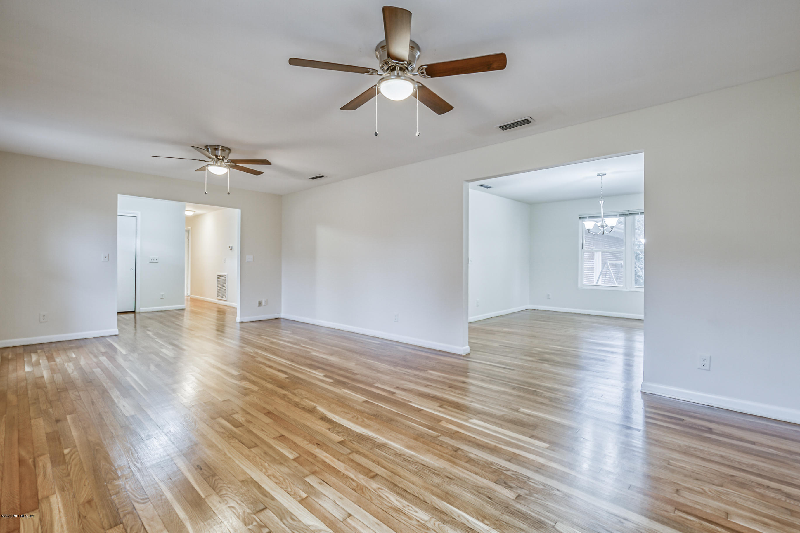 1305 Timber Lane Jacksonville, FL 32211 - Photo 20 of 58 a view of an empty room with wooden floor and a ceiling fan