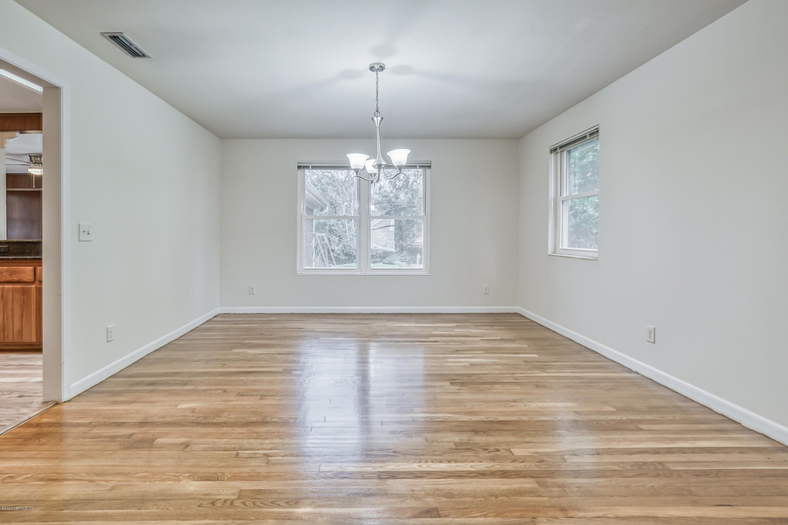 1305 Timber Lane Jacksonville, FL 32211 - Photo 22 of 58 an empty room with wooden floor chandelier and windows