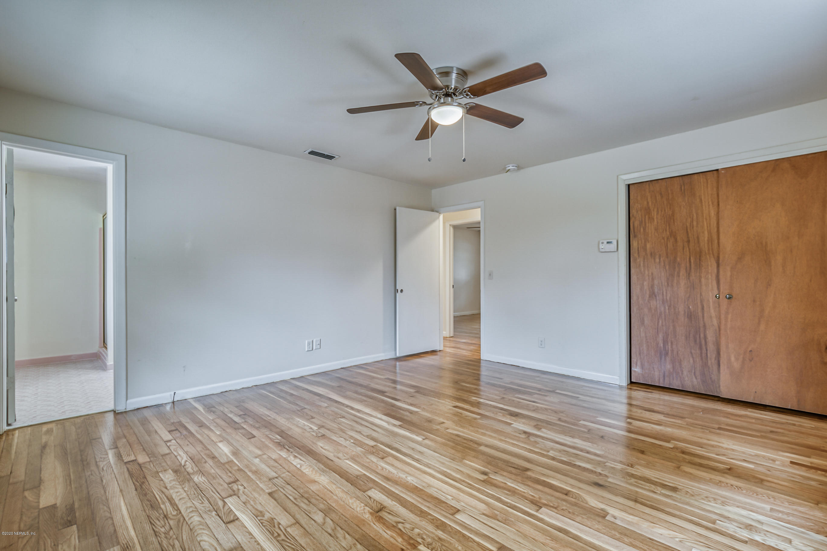 1305 Timber Lane Jacksonville, FL 32211 - Photo 33 of 58 an empty room with wooden floor fan and windows