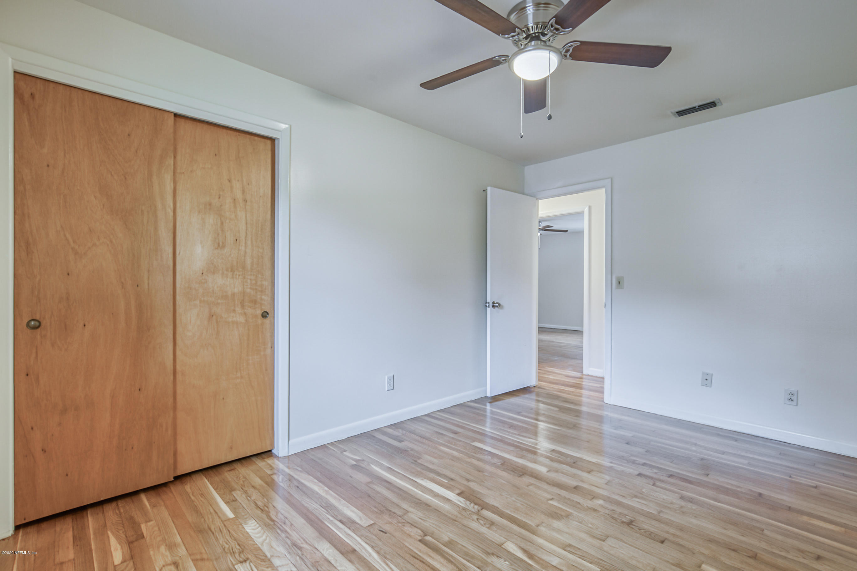 1305 Timber Lane Jacksonville, FL 32211 - Photo 37 of 58 an empty room with wooden floor closet fan and windows