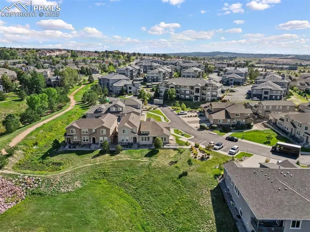 an aerial view of residential houses with outdoor space and parking