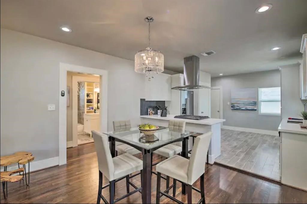 5224 Leeland Street Houston, TX 77023 - Photo 7 of 16 a view of a dining room with furniture a chandelier and wooden floor