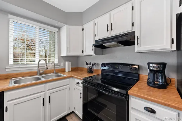 a kitchen with granite countertop a sink stove and cabinets