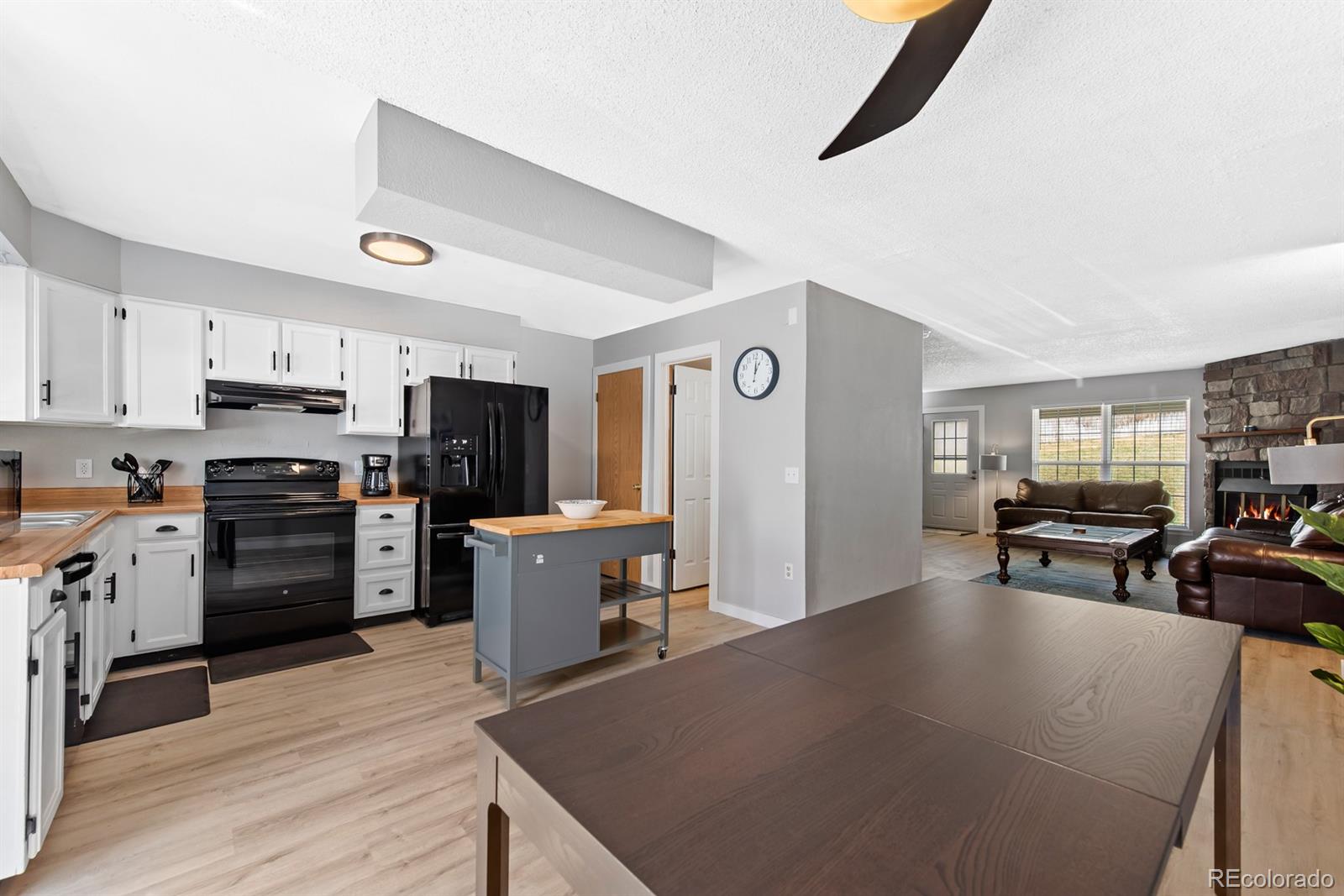 19927 Briarwood Court Parker, CO 80138 - Photo 17 of 29 a kitchen with stainless steel appliances kitchen island granite countertop a refrigerator a stove top oven a sink dishwasher and wooden cabinets with wooden floor