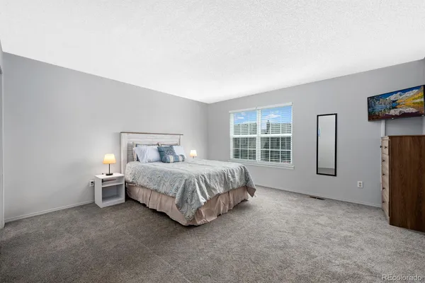 a spacious bedroom with a bed and a large window