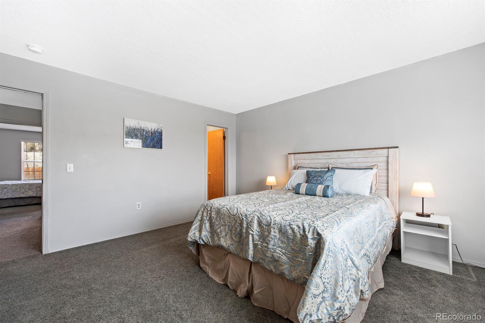 19927 Briarwood Court Parker, CO 80138 - Photo 20 of 29 a bedroom with a bed and a lamp