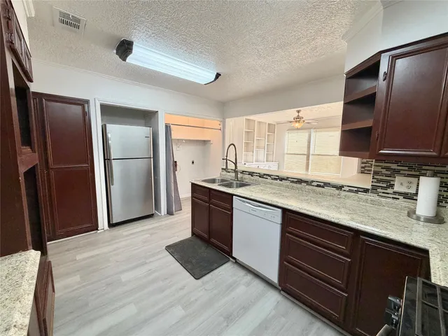 a kitchen with stainless steel appliances granite countertop a sink stove and refrigerator