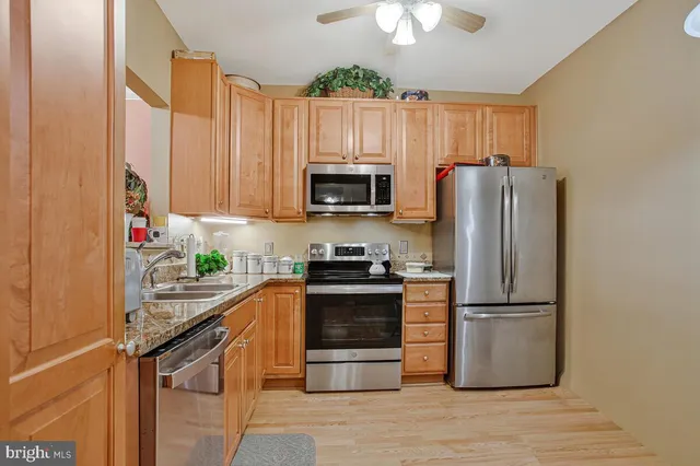 a kitchen with granite countertop a refrigerator stove and microwave