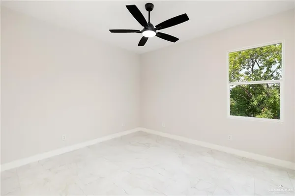 an empty room with a window and a fan