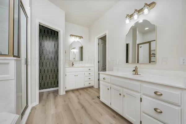 a bathroom with a double vanity sink and mirror with shower