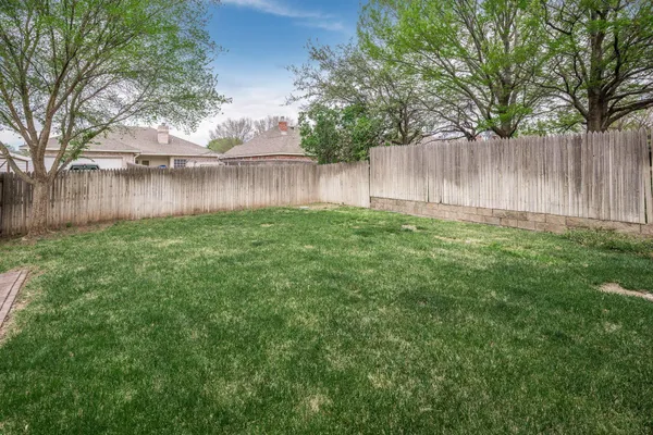 a view of a yard with wooden fence