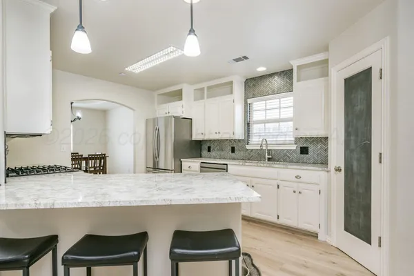 a kitchen with center island and chairs in it