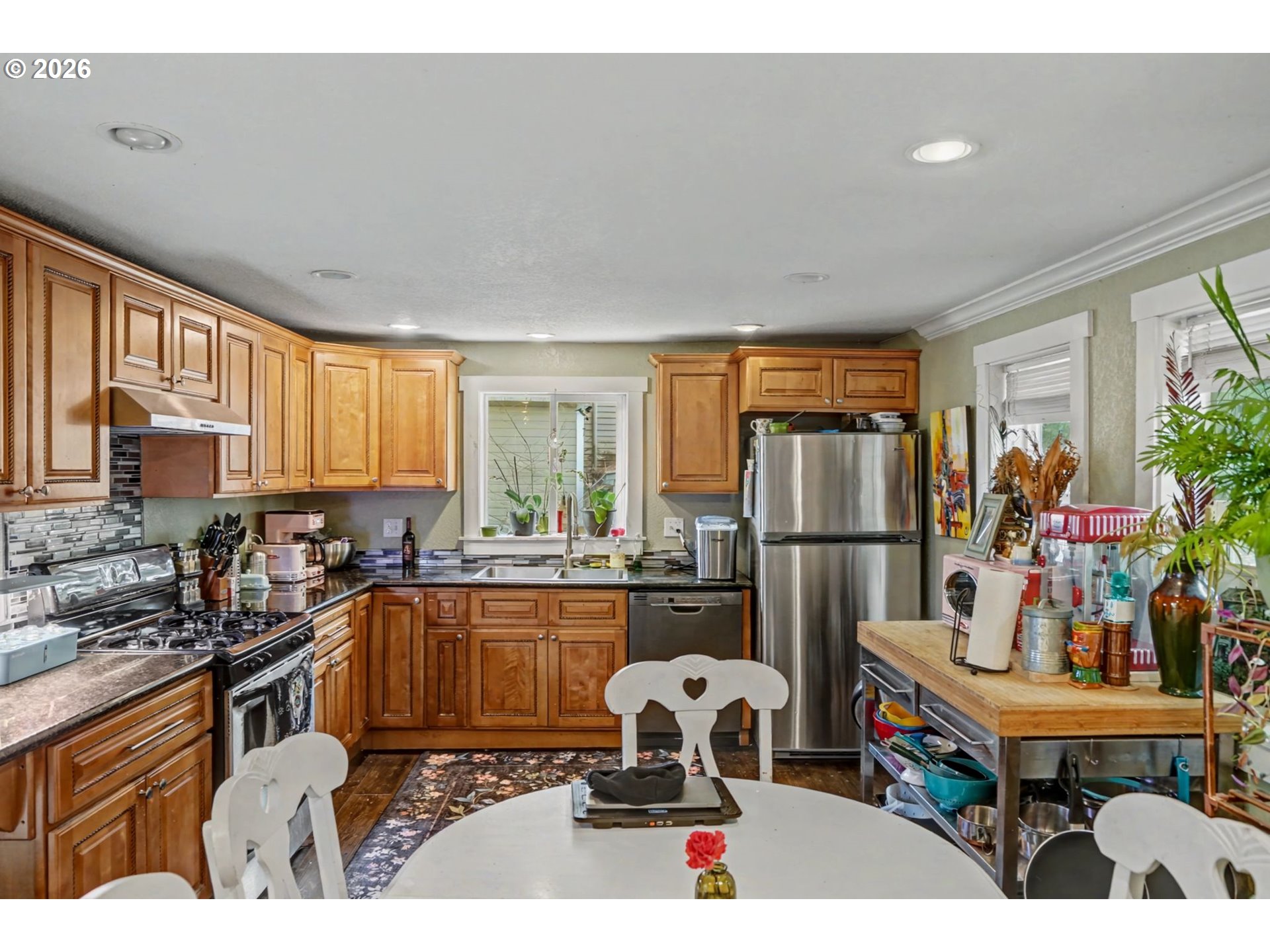 213 Mill Street Silverton, OR 97381 - Photo 10 of 25 a kitchen with a refrigerator a sink dishwasher a dining table and chairs with wooden floor