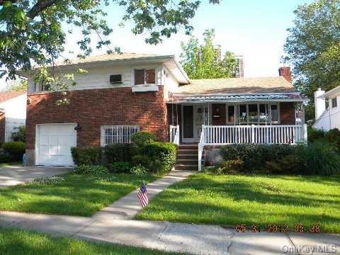 264-30 60th Road Queens, NY 11362 - Photo 1 of 1 a front view of house with yard and green space