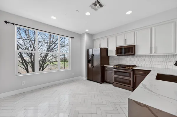 a large kitchen with a refrigerator and a stove top oven