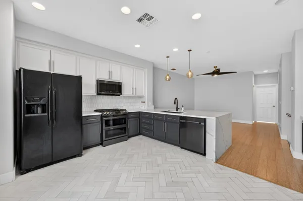 a large kitchen with a large center island wooden cabinets and stainless steel appliances