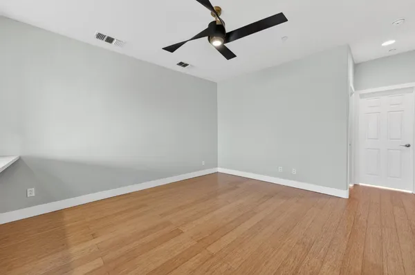 a view of a livingroom with a ceiling fan and wooden floor