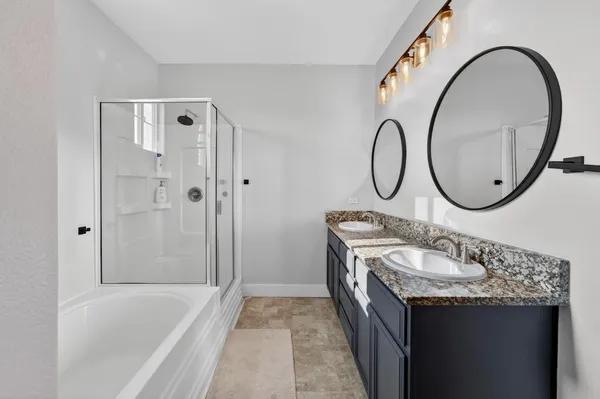 a bathroom with a granite countertop sink a mirror and a bathtub