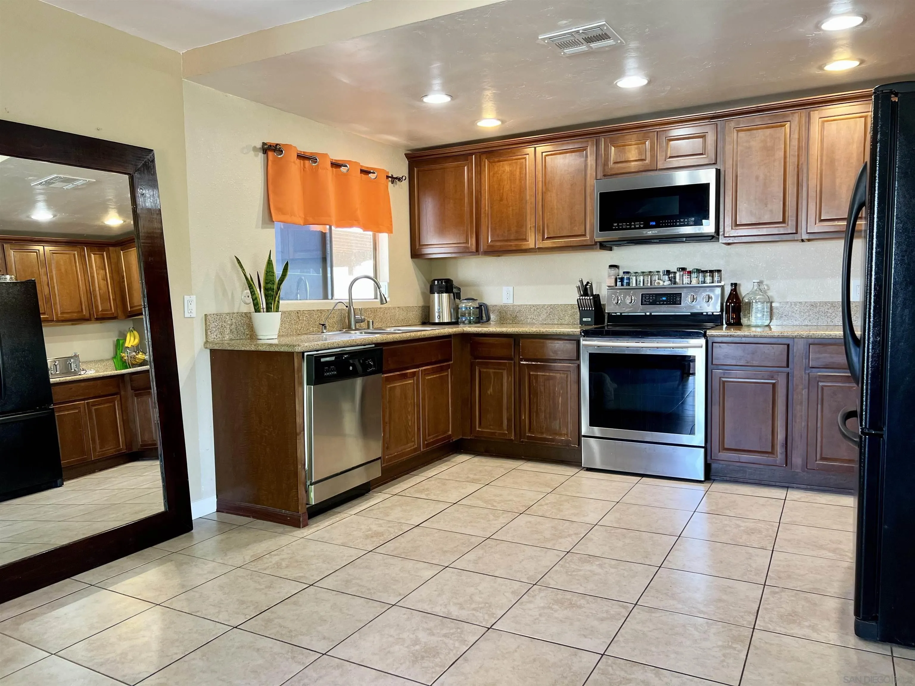 9849 Chestnut Street Spring Valley, CA 91977 - Photo 6 of 27 a kitchen with stainless steel appliances granite countertop a stove top oven a sink dishwasher and a microwave