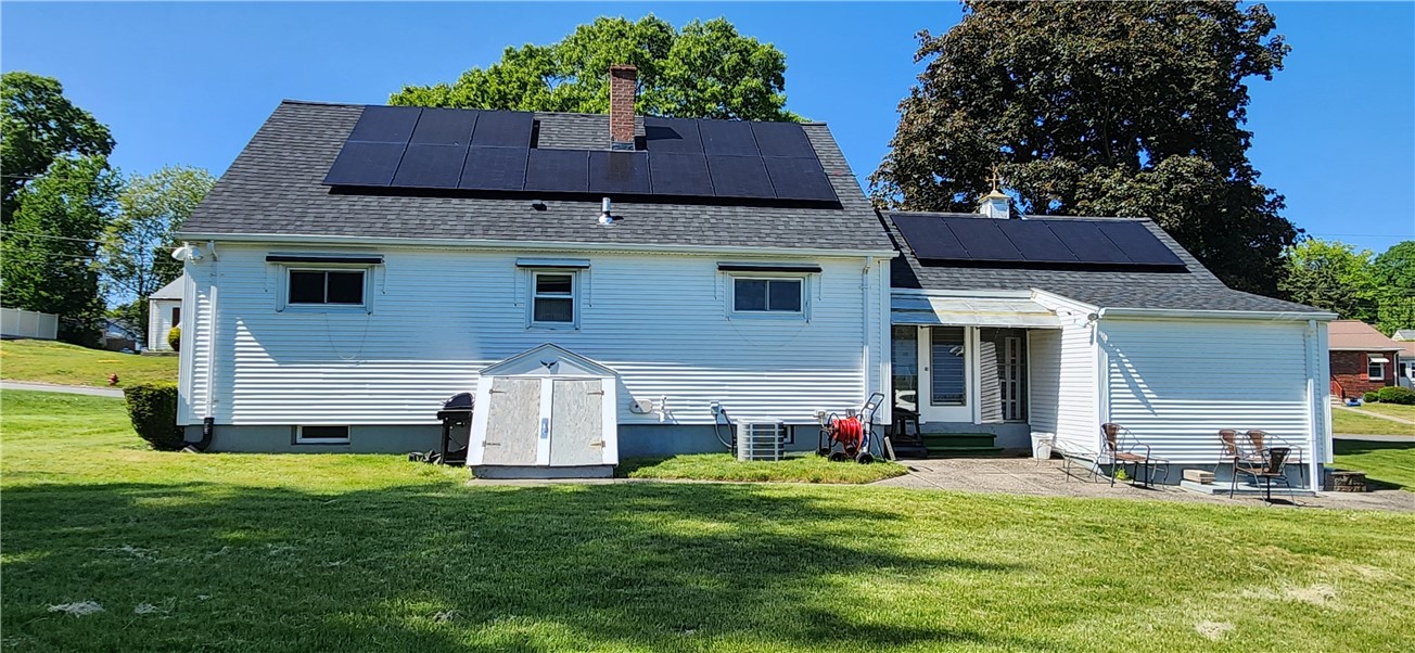 Large sun filled back yard with small shed.