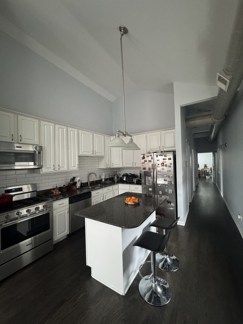 2315 West Harrison Street, Unit 4 Chicago, IL 60612 - Photo 5 of 9 a kitchen with stainless steel appliances granite countertop a stove a sink and a refrigerator