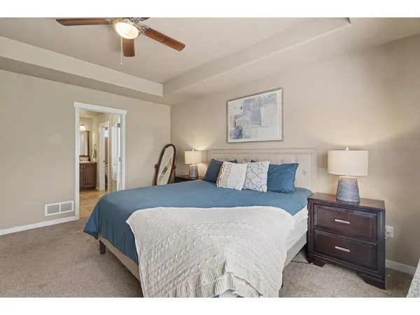 a spacious bedroom with a bed a table and chair