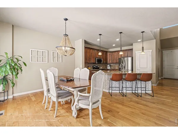 a dining room with furniture a chandelier and wooden floor