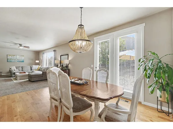a dining room with furniture a chandelier and window