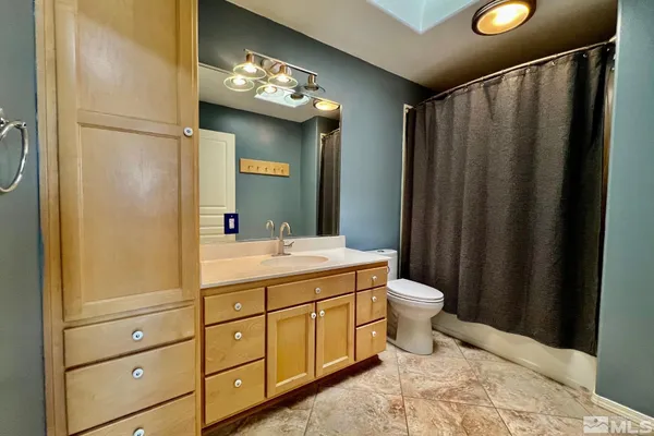 a bathroom with a double vanity sink toilet and mirror