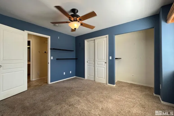 en empty room with closet and a ceiling fan
