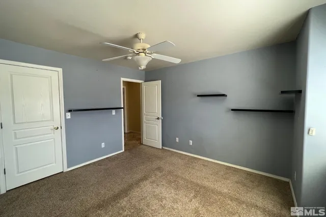 an empty room with closet and a chandelier fan
