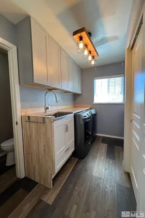 a kitchen with a sink cabinets stainless steel appliances and a window