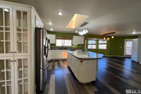 an open kitchen with granite countertop a stove and a wooden floors