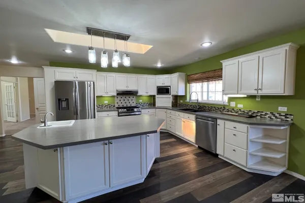 a kitchen with stainless steel appliances granite countertop a stove refrigerator and cabinets