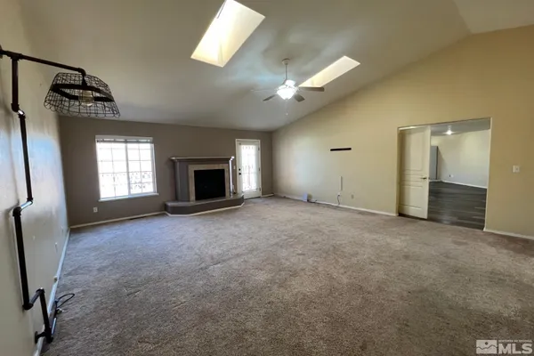 an empty room with windows and fireplace