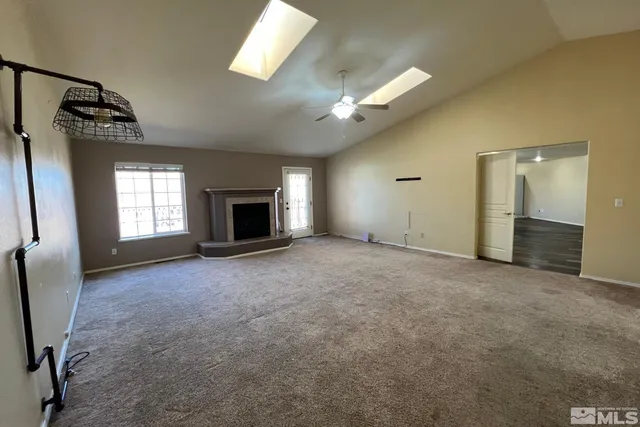 an empty room with windows and fireplace