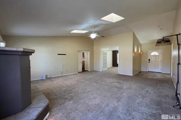 a view of a big room with a ceiling fan and a window