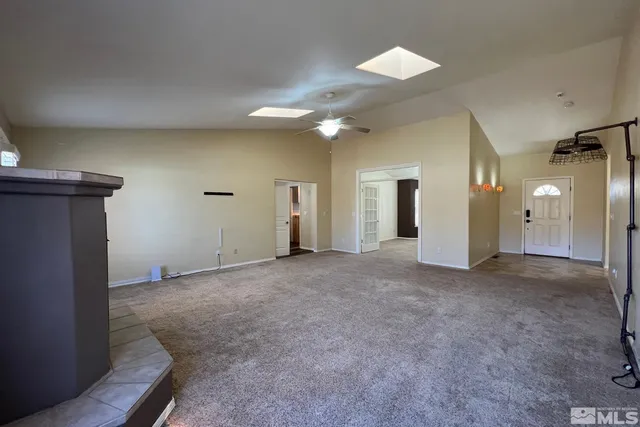 a view of a big room with a ceiling fan and a window